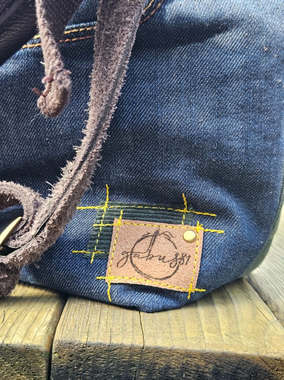 Denim crossbody bag Gabus81 Close up of handmade logo patch on denim bag with contrast stitching detail