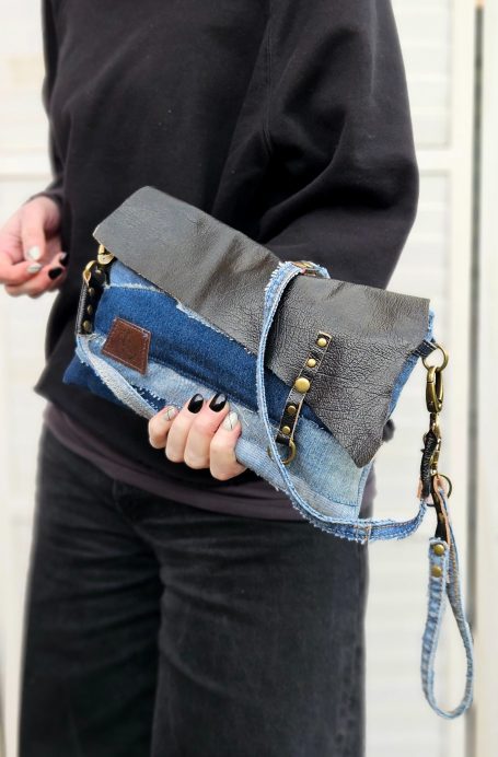 Denim Clutch Bags Small patchwork denim clutch bag with chain strap held in hand