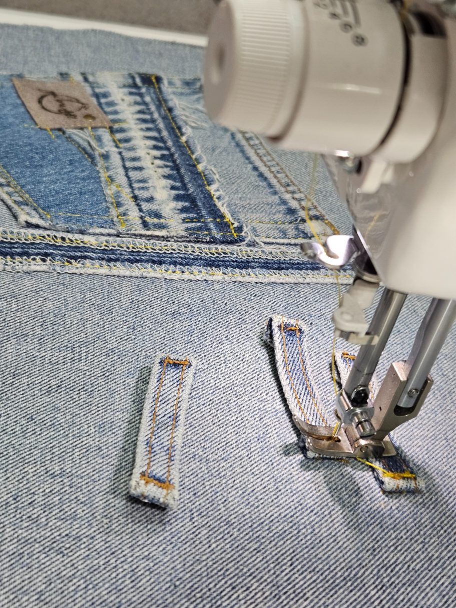 Light Denim Crossbody Bag With Pockets Close up of reclaimed denim fabric and sewing detail during the bag making process
