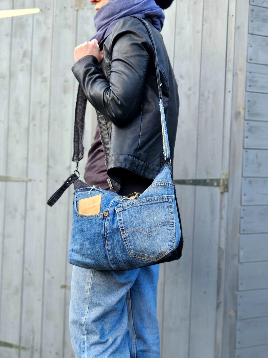Denim Crossbody Bag Blue denim crossbody bag worn with black jacket, showing casual everyday style and practical size.