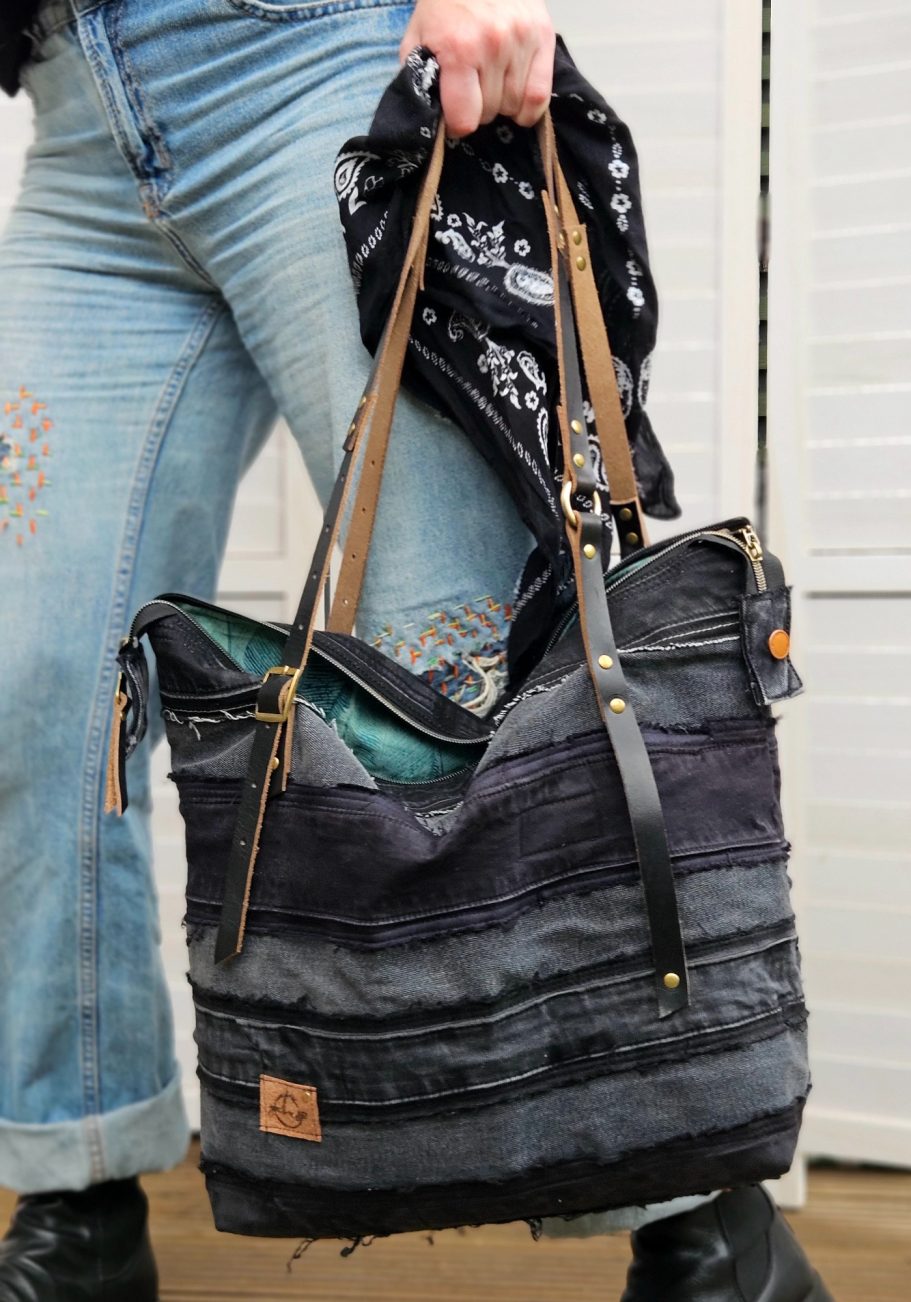 Denim Shoulder Bag Black reclaimed denim tote bag with front pockets, leather zip pulls and open top detail.