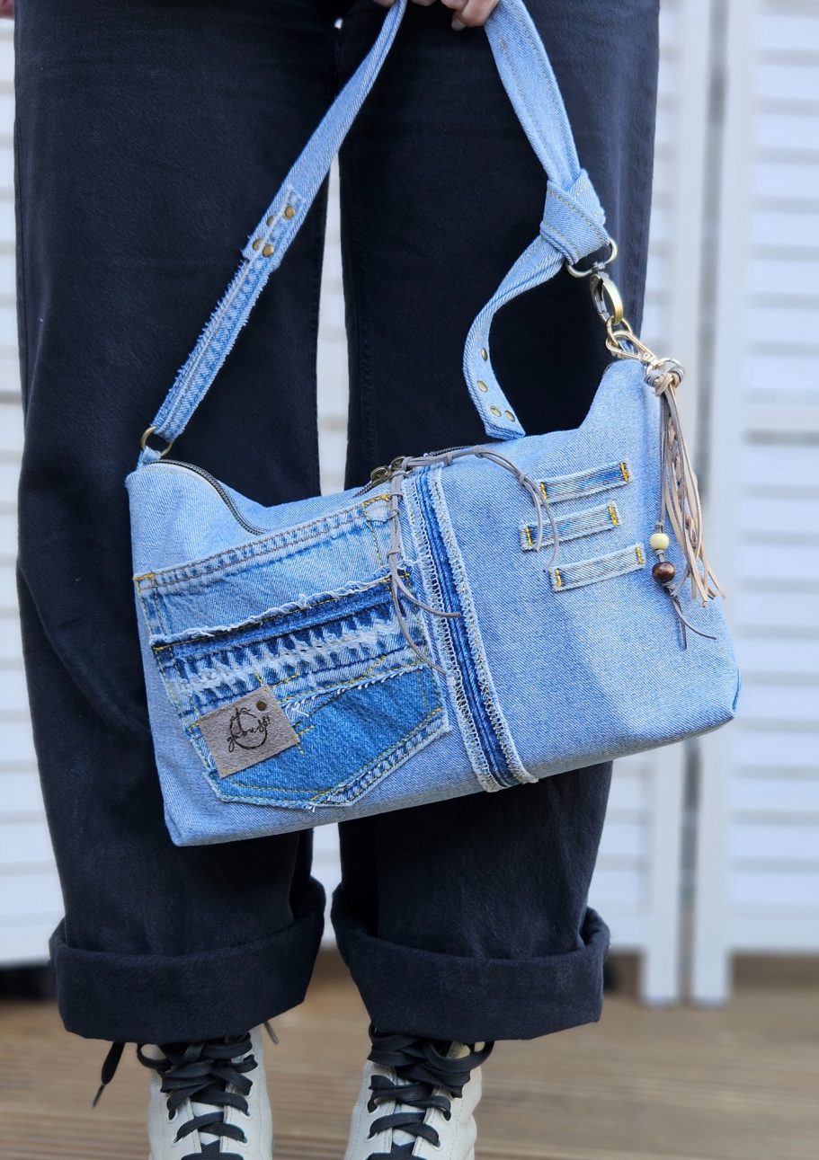 Light Denim Crossbody Bag With Pockets Light denim crossbody bag worn crossbody with front pockets and adjustable strap