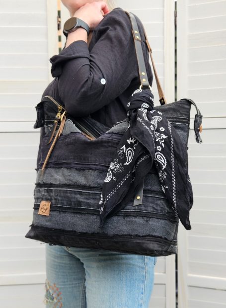 Black Denim Shoulder Bag Black denim shoulder bag styled with a dark casual outfit, showing its relaxed everyday tote shape.
