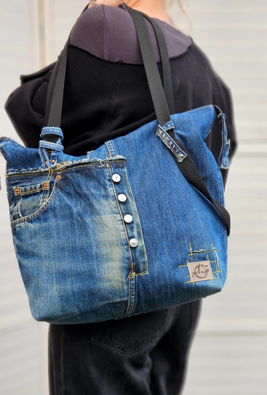 Handmade Denim Tote with Attitude Handmade upcycled denim tote bag worn on the shoulder with front jeans pocket and zip closure