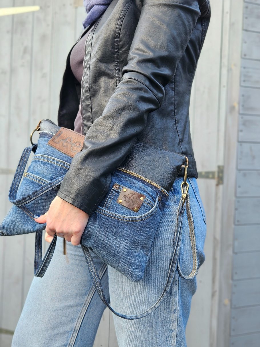 Denim Clutch Denim clutch bag worn with black leather jacket and casual jeans, showing scale and everyday styling.
